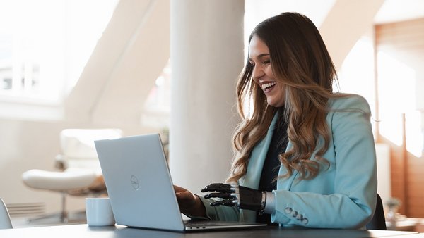 Das sind die Vorteile von Digital Networking Lachende Frau beim digitalen Netzwerken am Laptop