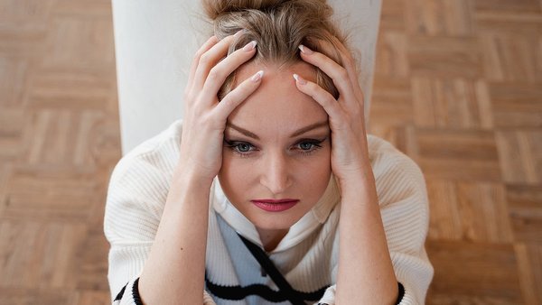Frau stützt gestresst den Kopf auf die Hände