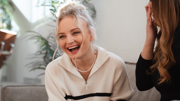 Persönliche Ziele setzen und als Kraftquelle nutzen Lachende Frau mit Kollegin motiviert sich selbst bei der Arbeit