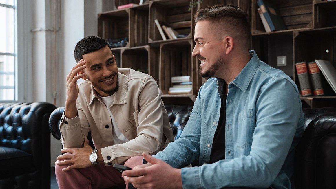 Die junge Generation und die Rente Zwei Studenten reden miteinander auf einer Couch