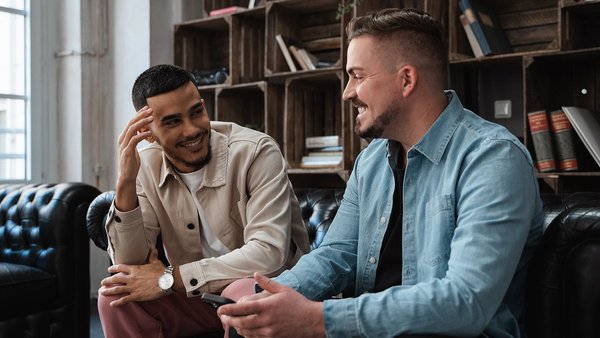 Zwei Studenten reden miteinander auf einer Couch