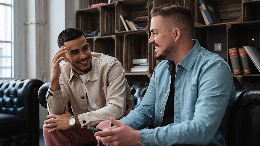 Zwei Studenten reden miteinander auf einer Couch