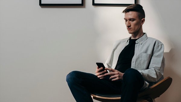 Mann guckt besorgt auf sein Handy – Preissteigerung Mann guckt besorgt auf sein Handy – Preissteigerung