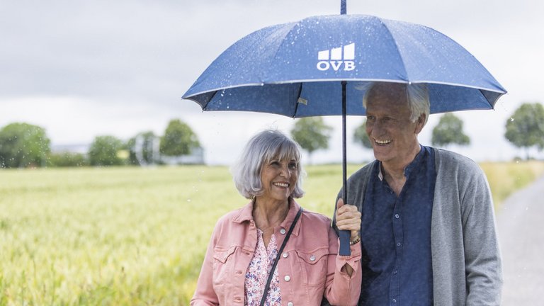 Älteres Paar unter einem Regenschirm.