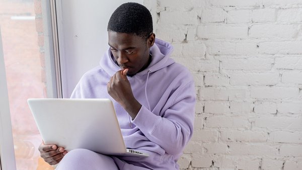 Student sitzt grübelnd vor einem Laptop