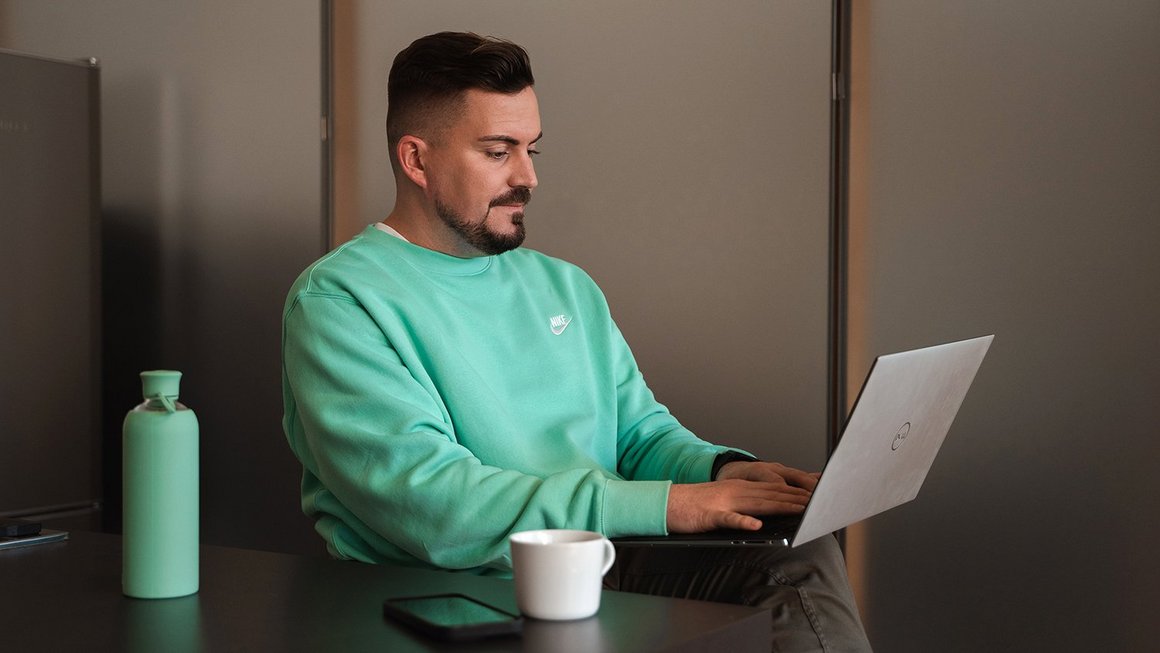 Das Wichtigste zum Thema Wiedereinstieg nach der Elternzeit Junger Vater arbeitet am Laptop beim Wiedereinstieg nach der Elternzeit