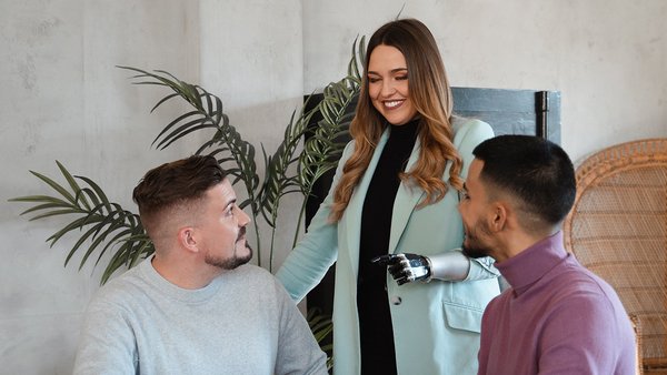 Drei Mitarbeitende unterhalten sich und bauen Vertrauen im Team auf