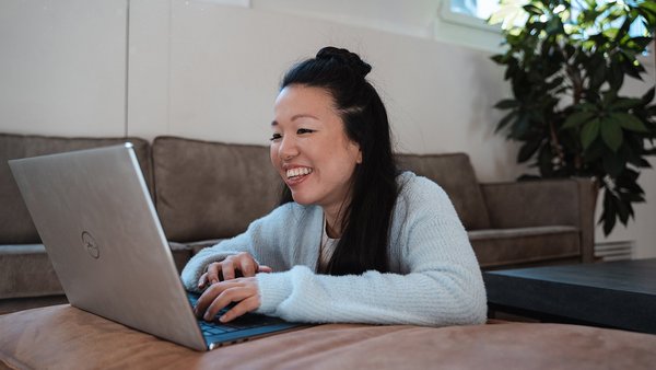 Stresslevel verringern Junge Frau arbeitet motiviert am Laptop