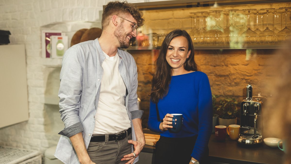Frau und Mann lachend im Gespräch.