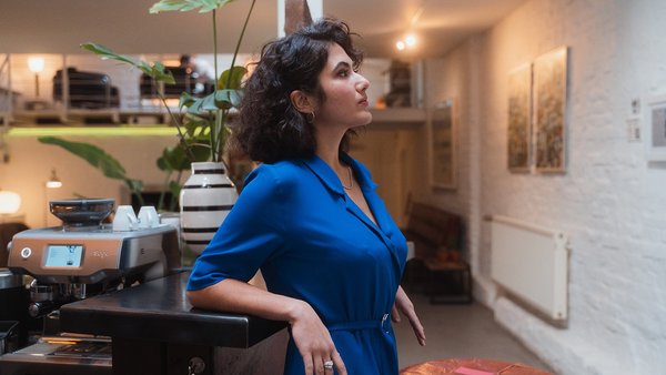 Eine Frau schaut konzentriert, während sie an einer Theke lehnt