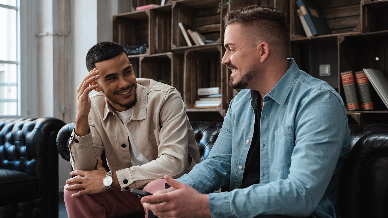 Die junge Generation und die Rente Zwei Studenten reden miteinander auf einer Couch