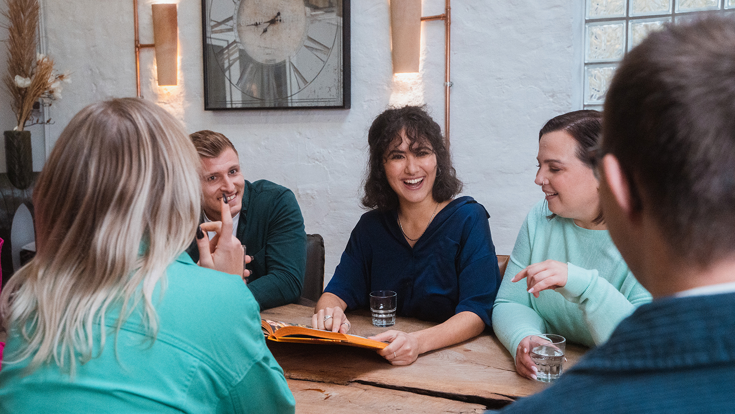 Team sitzt lachend im Meeting zusammen