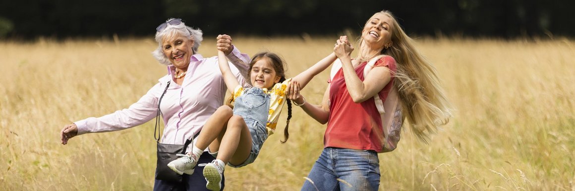 Oma und Mutter spielen im Freien mit Kind