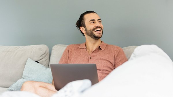 Im Grunde sind alle einer Meinung – auch über Ländergrenzen hinweg Mann mit Laptop auf dem Sofa