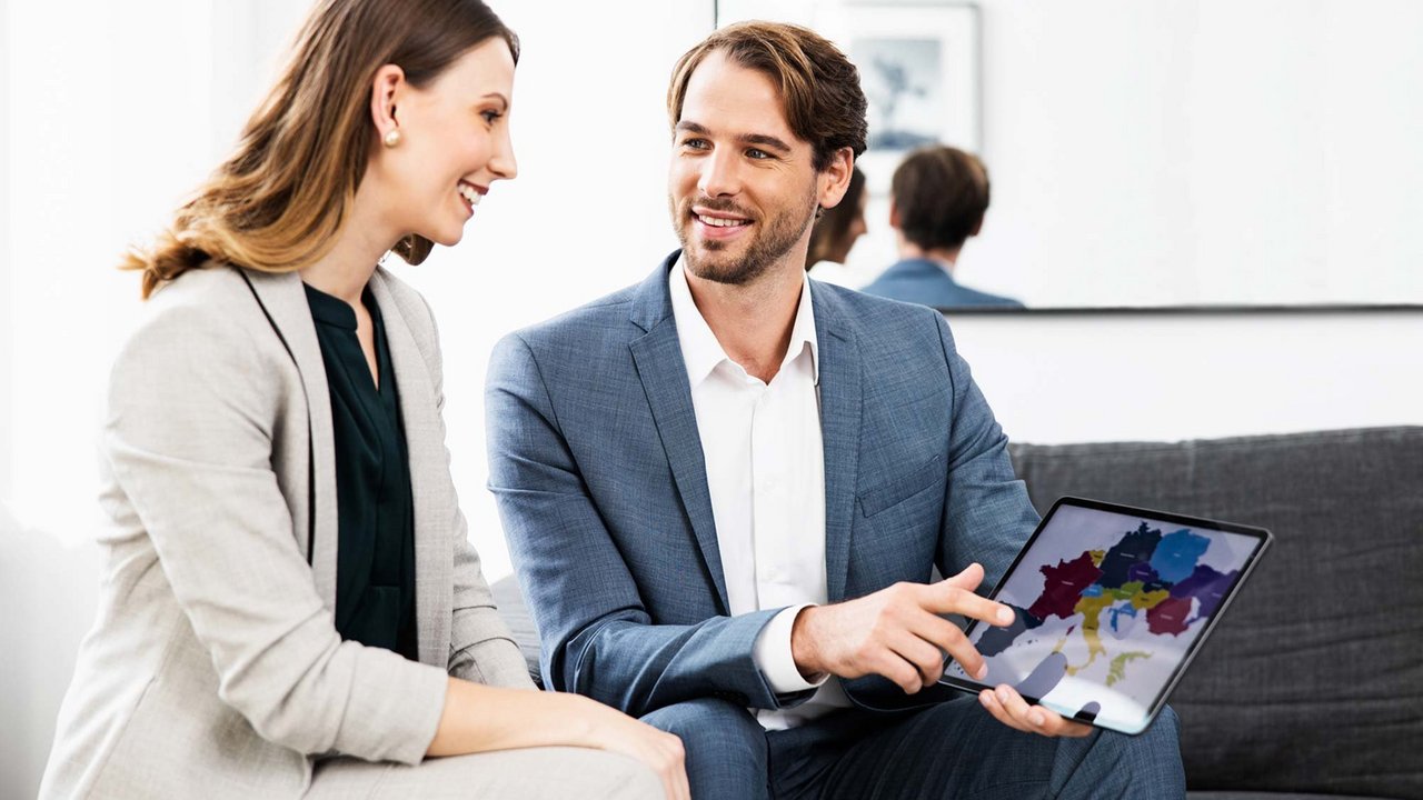 OVB Berater erklärt die OVB einer Frau auf dem Tablet.