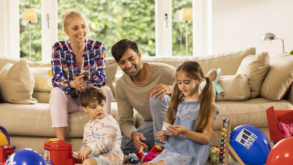 Glückliche Familie im Wohnzimmer mit Luftballoons beim Spielen