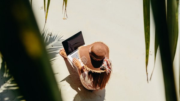Frau arbeitet am Strand – Remote Work im Ausland Frau arbeitet am Strand – Remote Work im Ausland