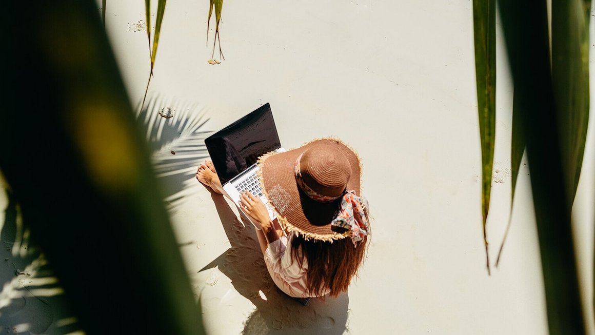 Frau arbeitet am Strand – Remote Work im Ausland Frau arbeitet am Strand – Remote Work im Ausland