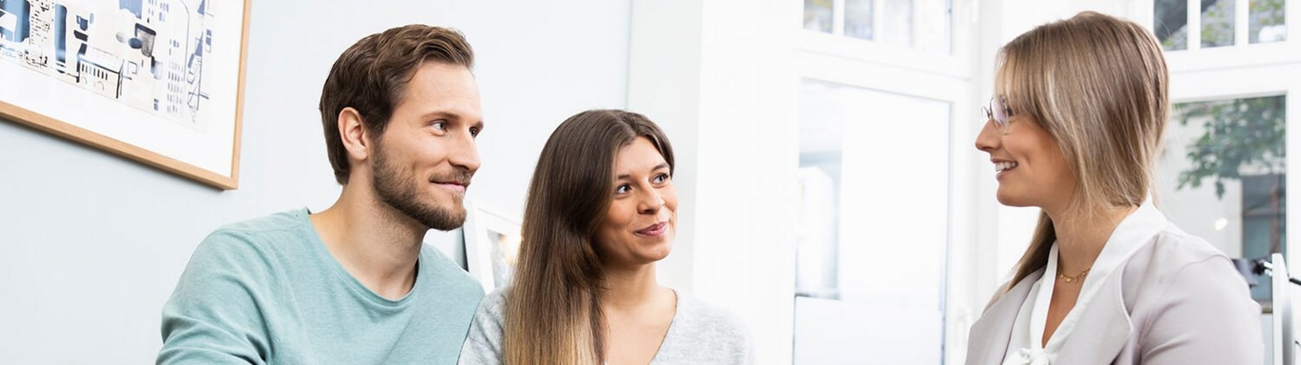 Ein Mann und zwei Frauen unterhalten sich interessiert.